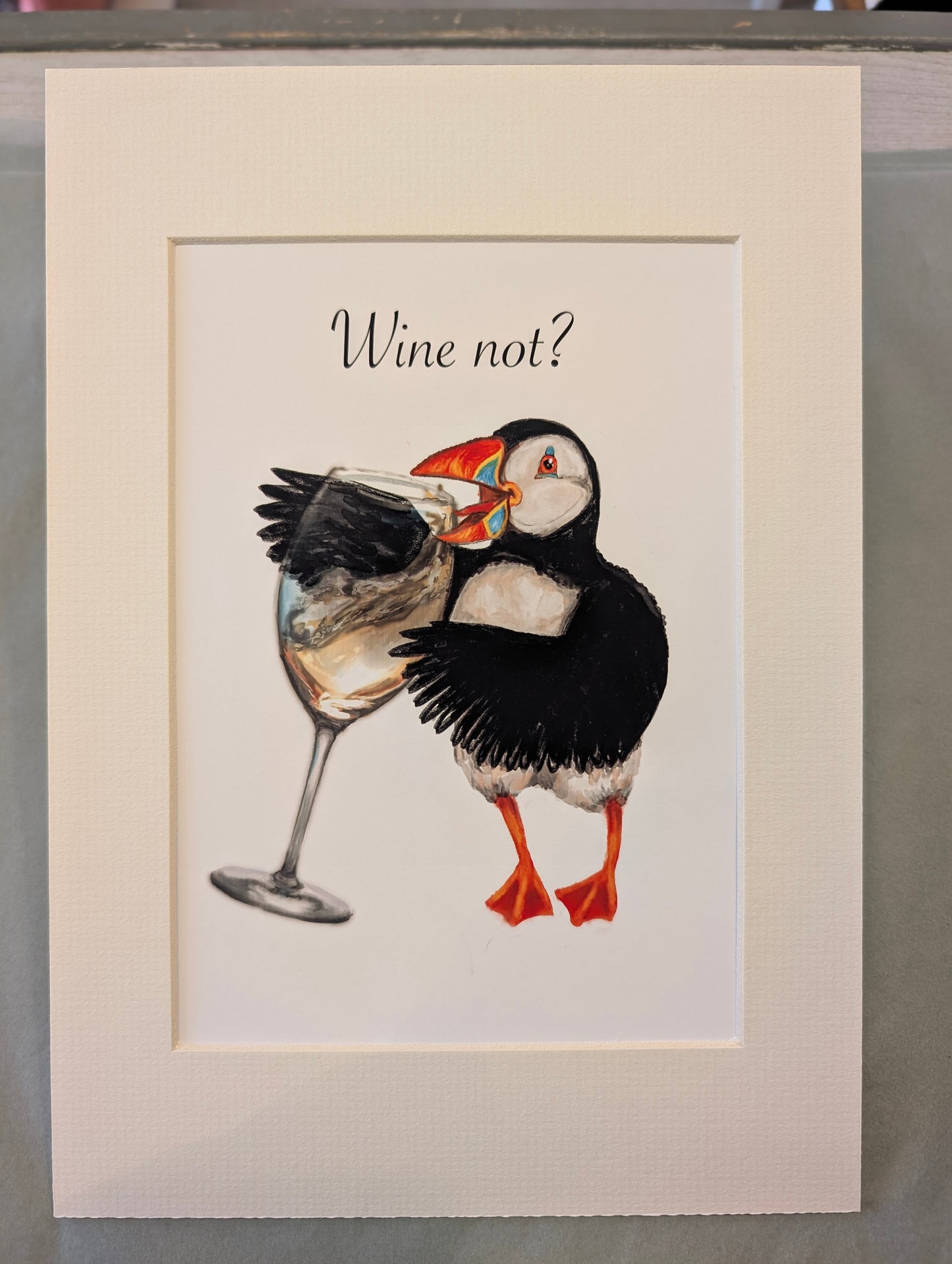Puffin art print – puffin drinking white wine, whimsical wall decor for wine lovers and coastal homes.
Whimsical illustration of a puffin eagerly drinking white wine from a glass, mixed media art in watercolour, gouache, and digital.
By Welsh coastal illustrator Rachel Bennett